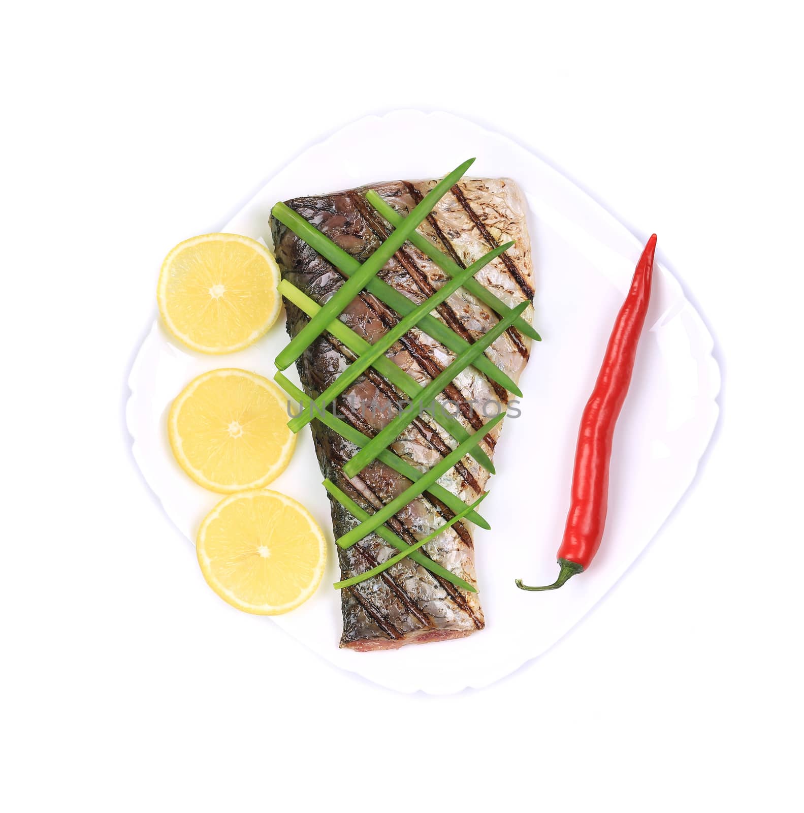 Grilled carp fillet on plate with onion and lemon. Isolated on a white background.