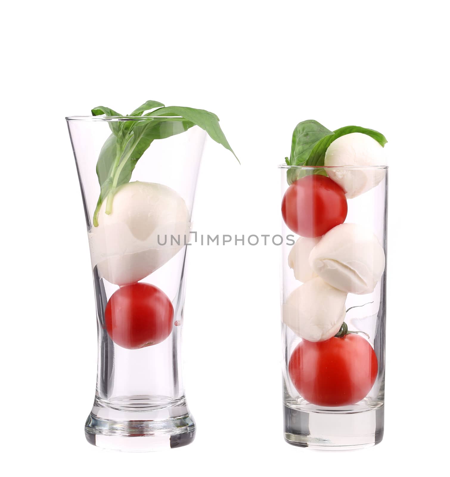 Tomatoes and mozzarella balls in glass. by indigolotos