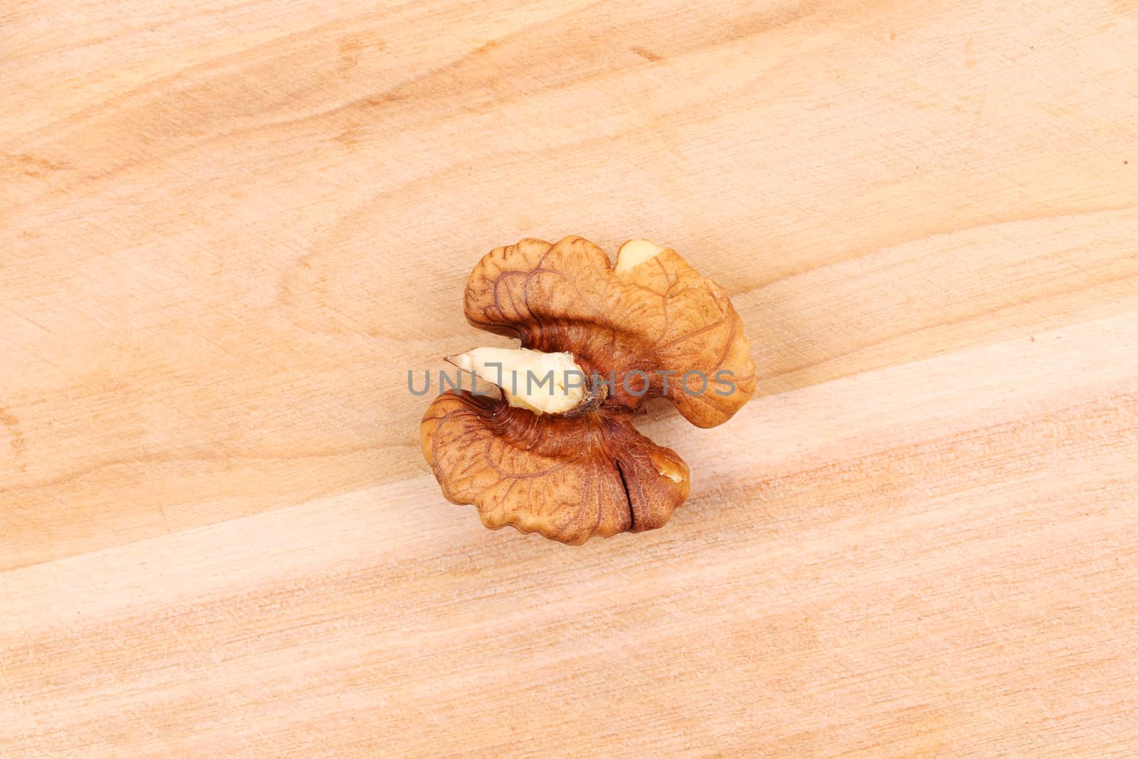 Walnut kernel on wooden background. Close up. by indigolotos