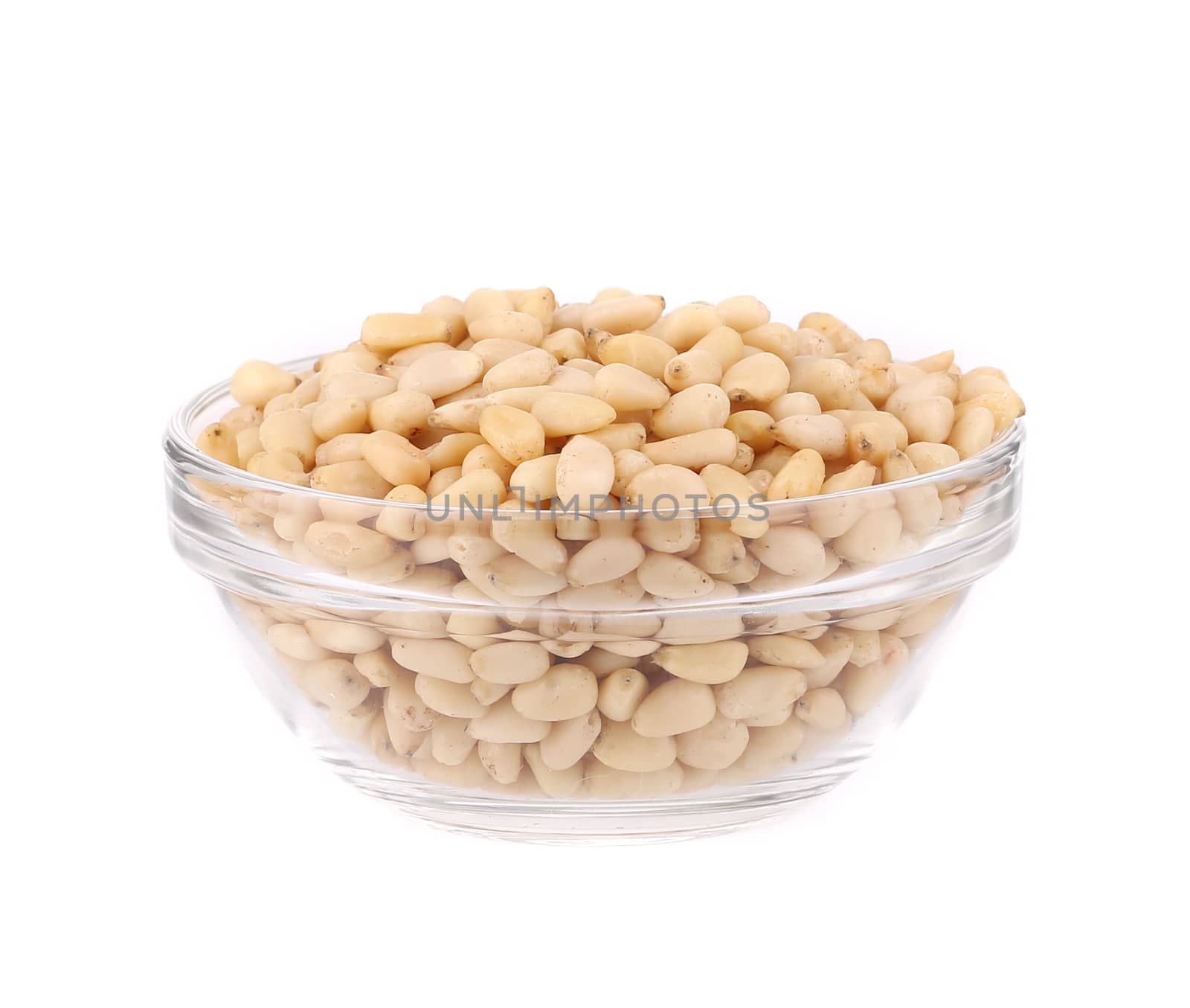Glass bowl with pine nuts. Isolated on a white background.