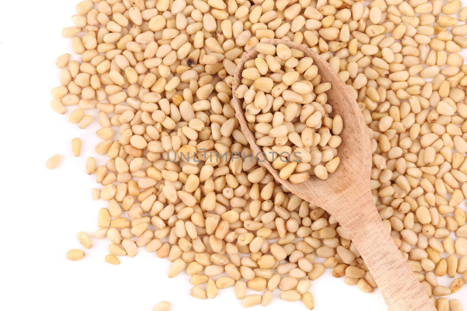 Bunch of pine nuts with wooden spoon. Whole background.