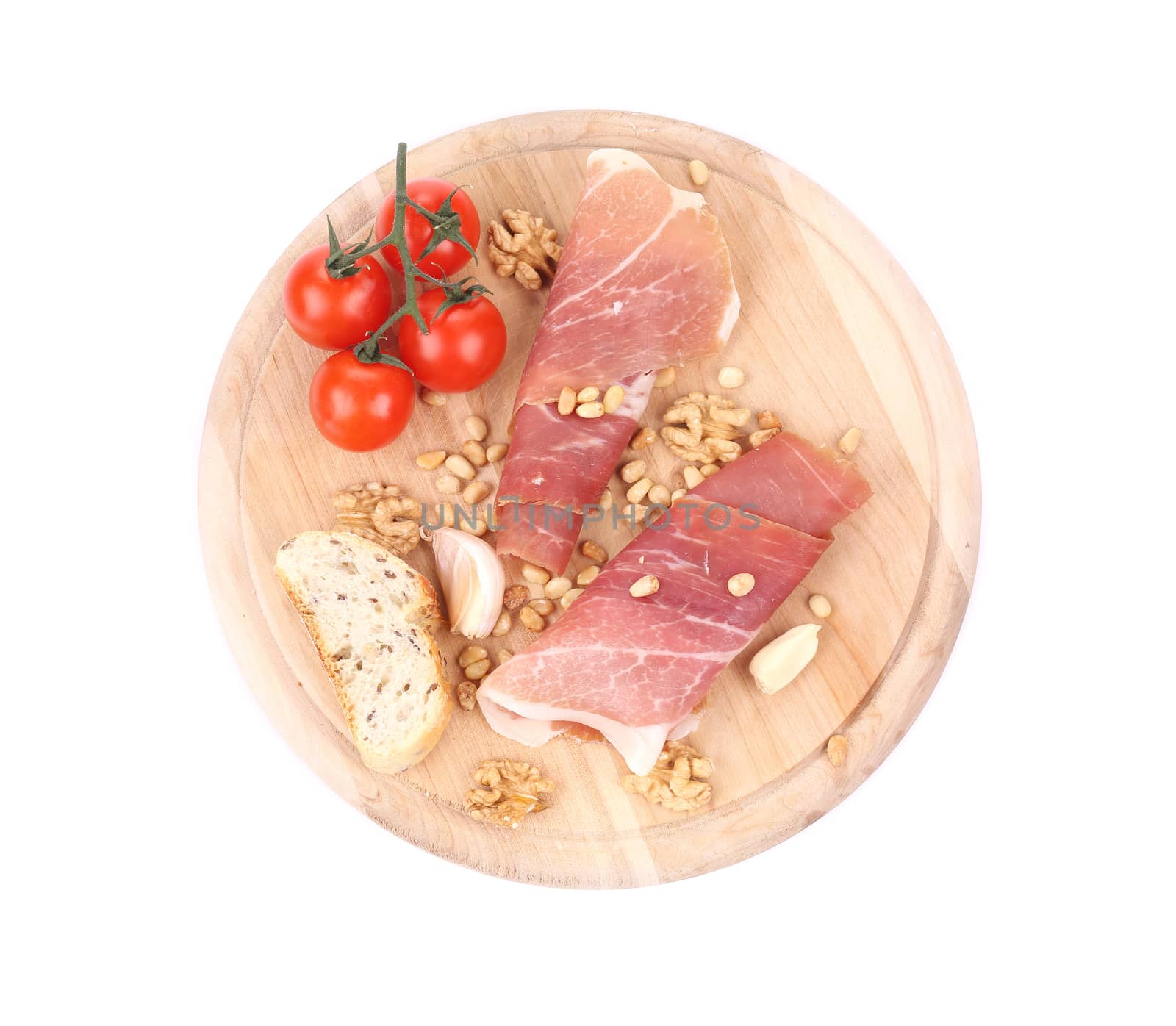 Composition of prosciutto on wooden platter. Isolated on a white background.