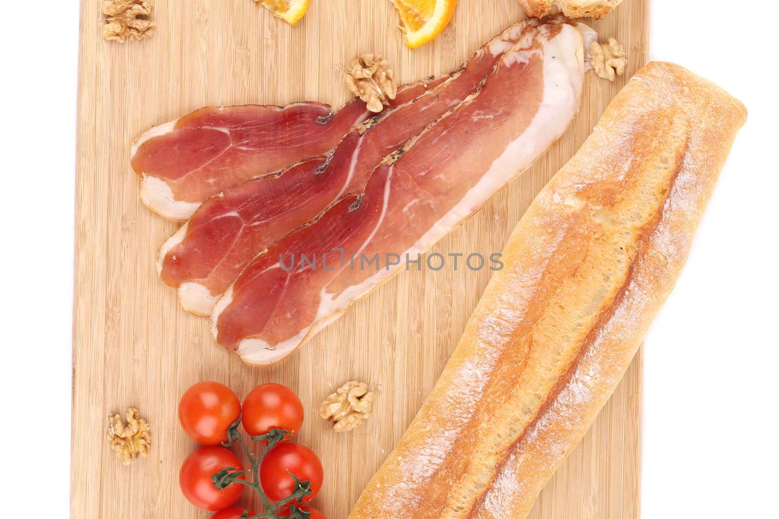 Prosciutto with cherry tomatoes and walnuts. Whole background.