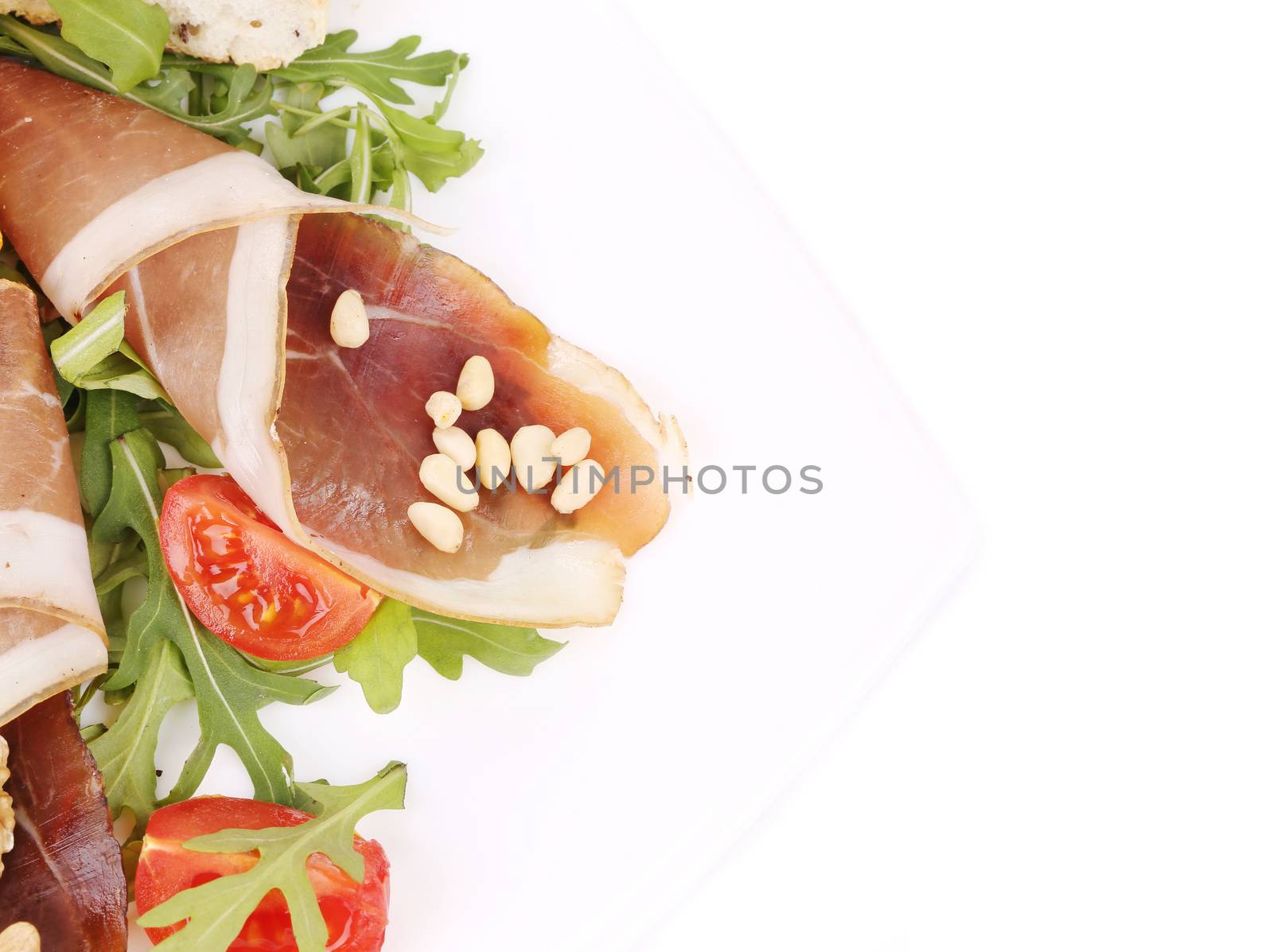 Salad with arugula and prosciutto. Whole background.