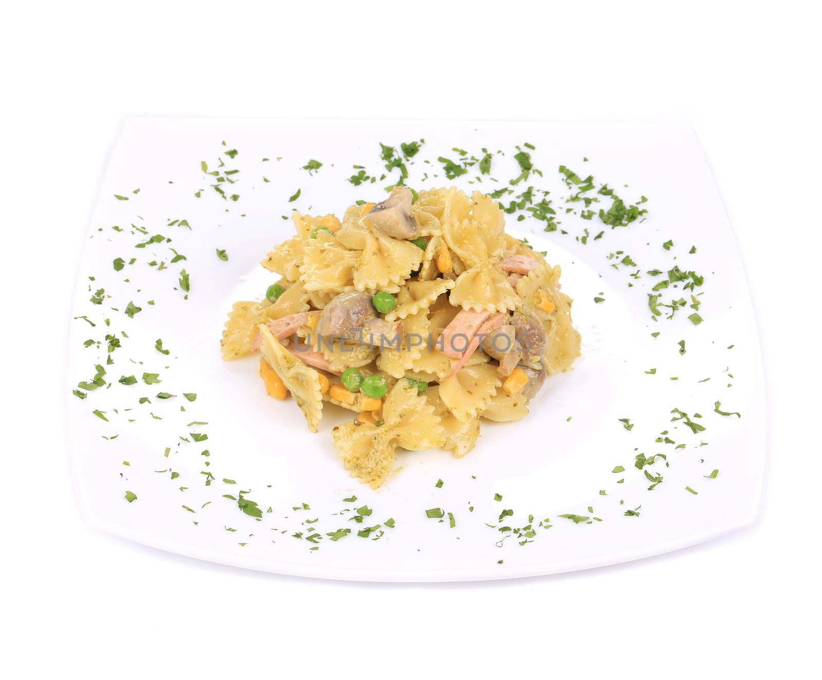 Pasta with ham and mushrooms in sauce pesto. Isolated on a white background.