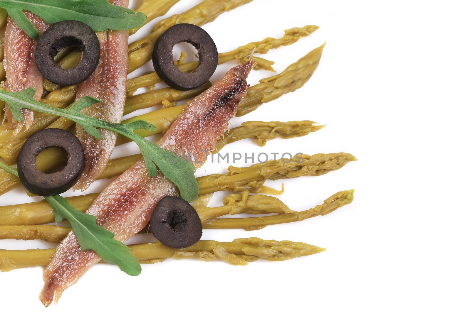 Asparagus salad with anchovies. Isolated on a white background.