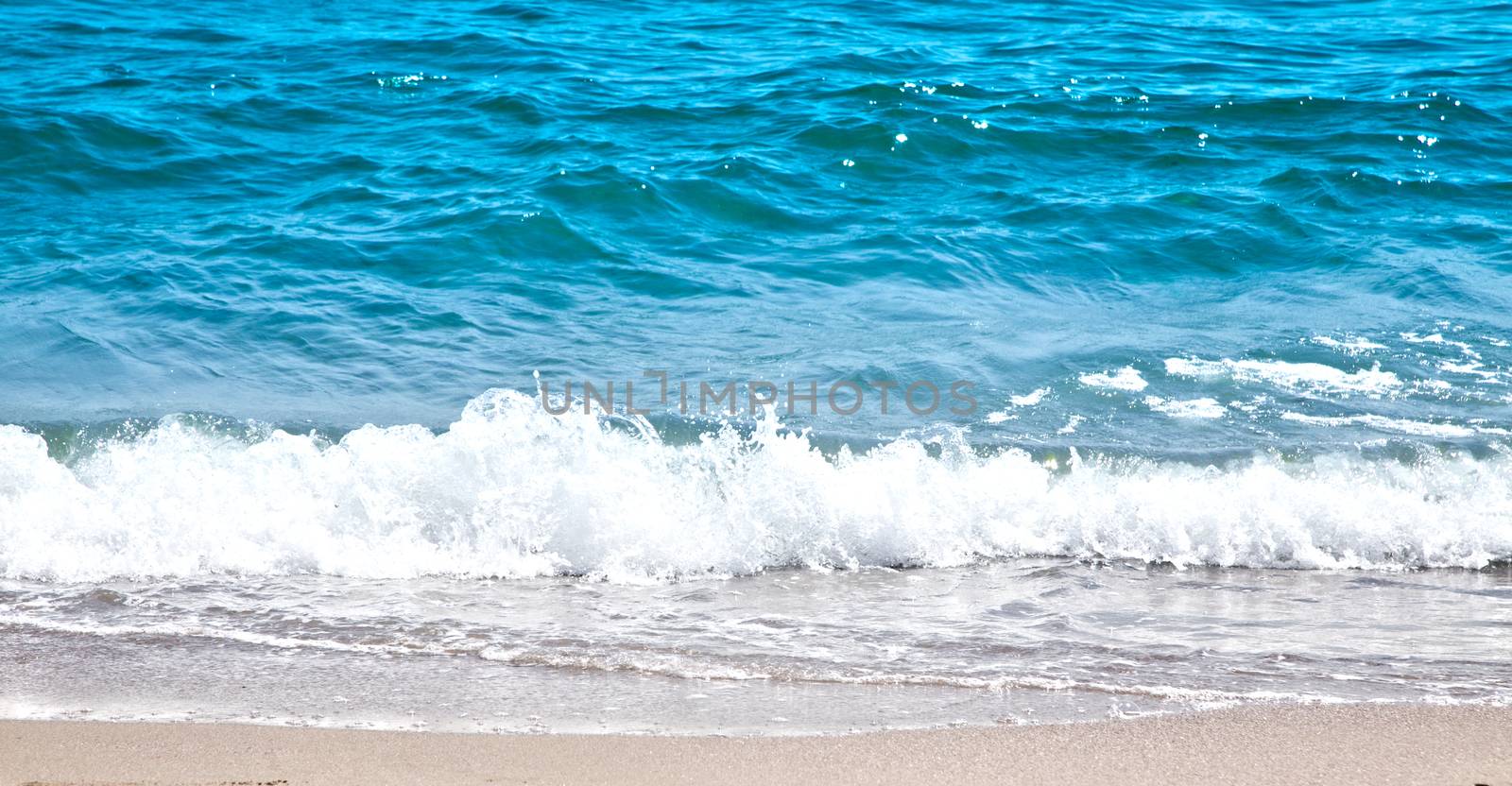 Beautiful ocean surf and white foam near coast.