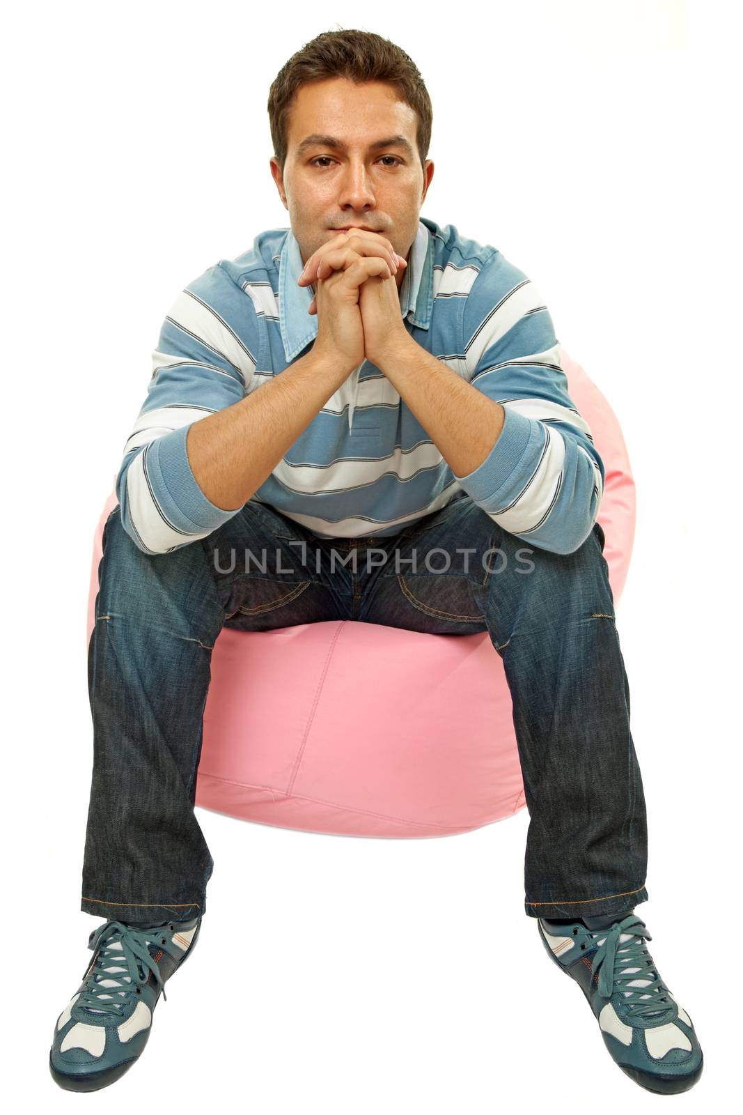 young casual man seated in a small sofa