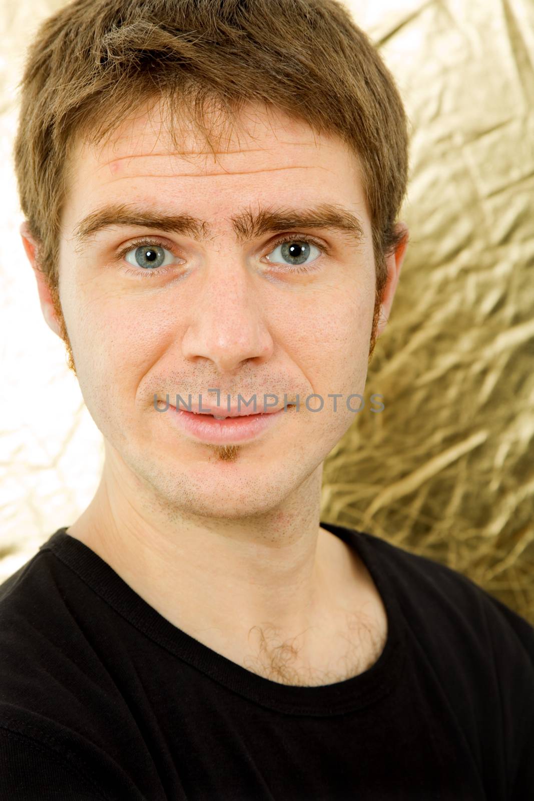 young casual man against a golden background