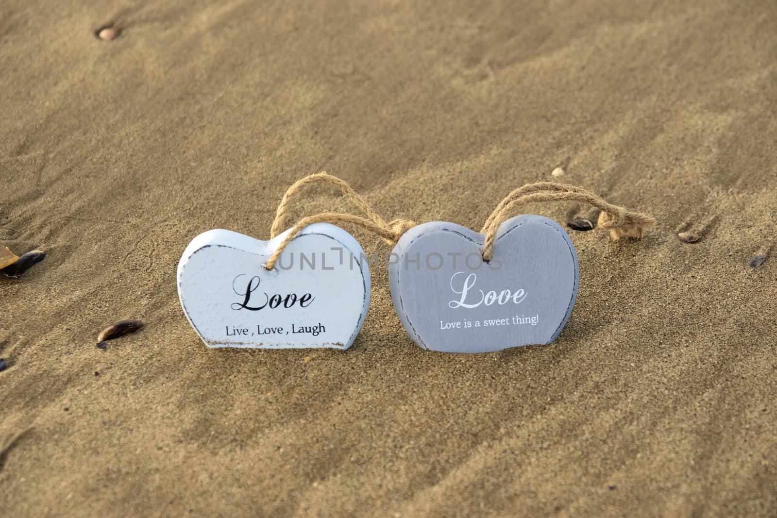 two inscribed wooden love hearts in the quick sand by morrbyte