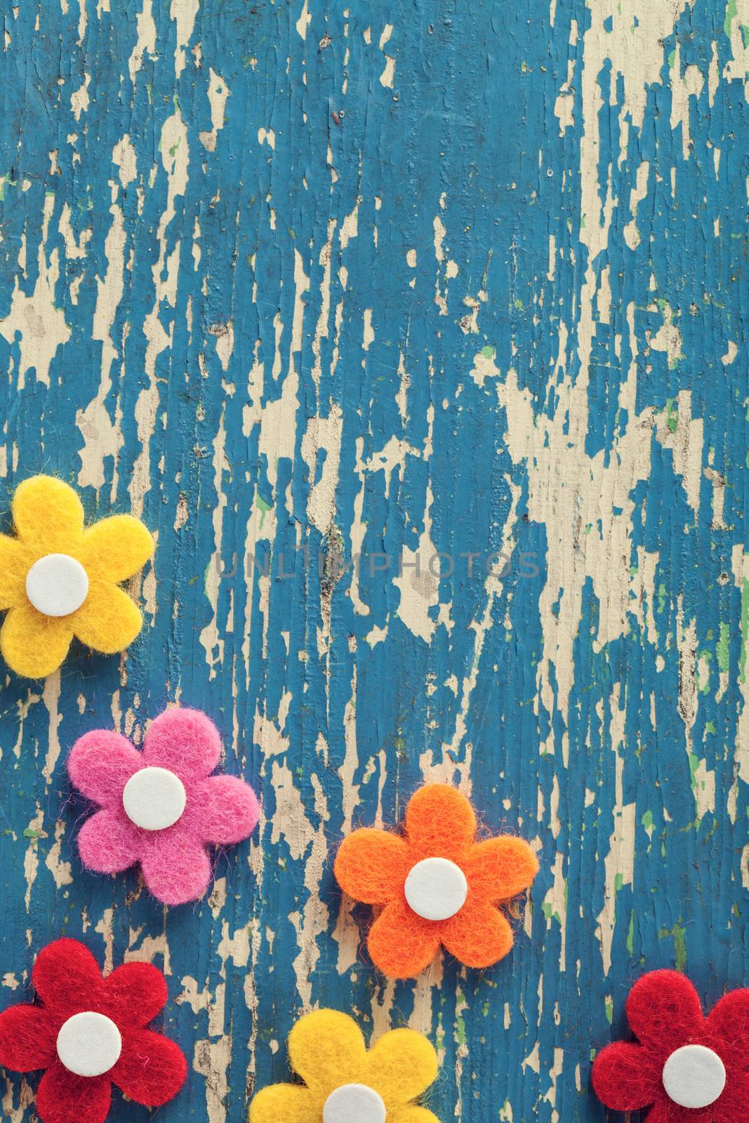 Spring felt flowers on wooden table background. Top view