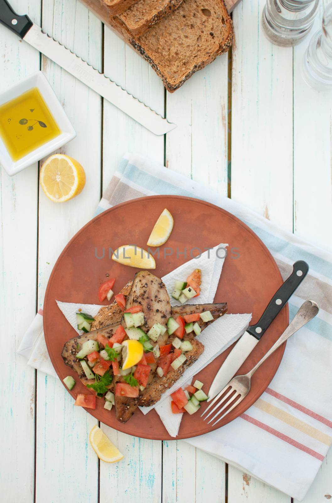 Smoked mackerel fish with freshly chopped cucumber and tomato topping on a thick slice of bread 