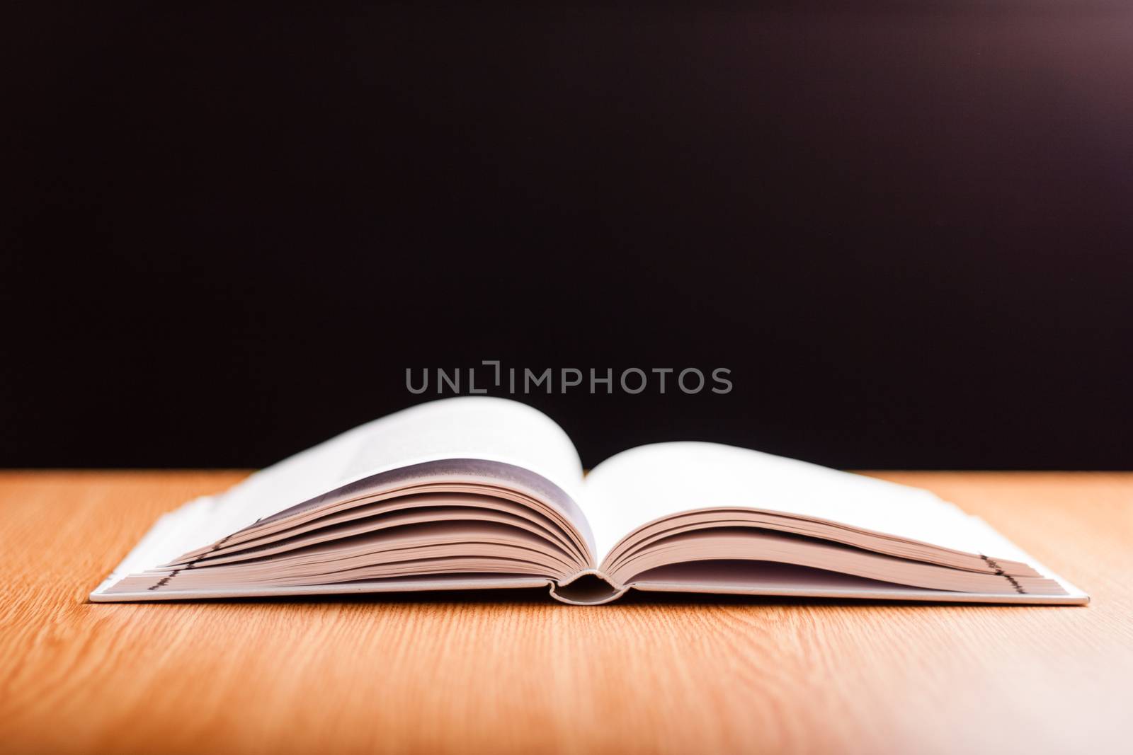 open book with white pages on wooden table