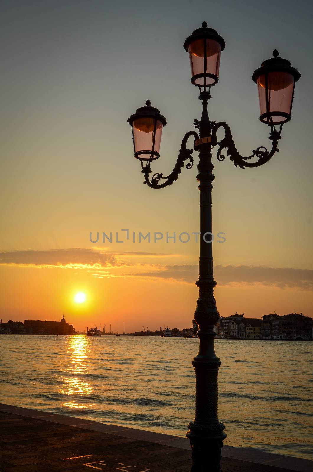 Sunset Over The City Of Venice, Italy With Streetlamps In The Foreground