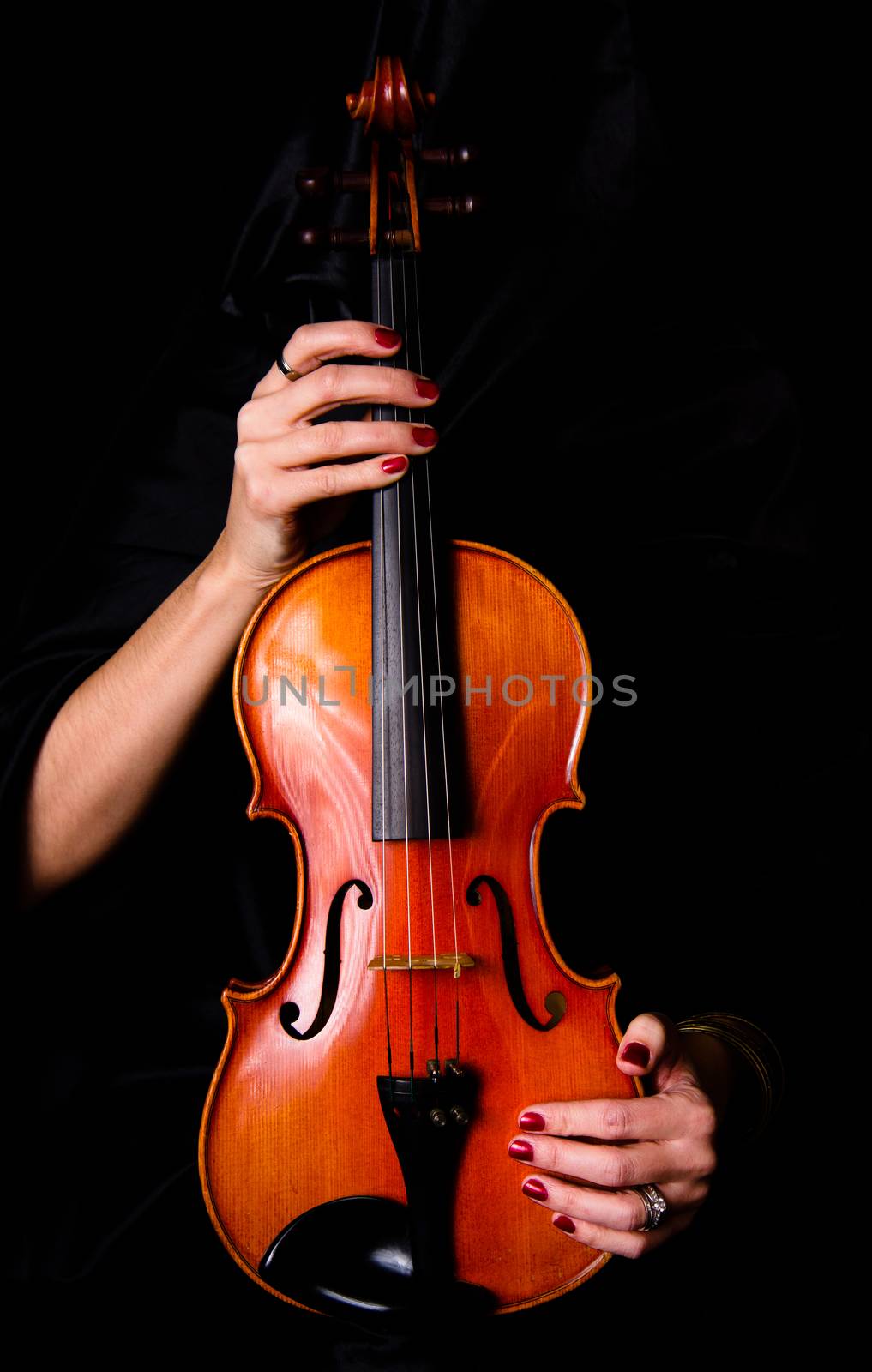 Woman draped in black hold her violin