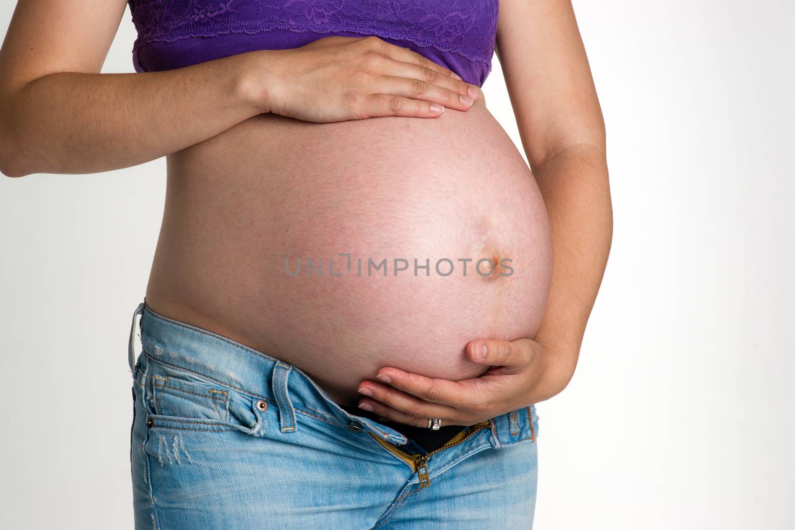 A woman tries to support her belly enduring pregnancy