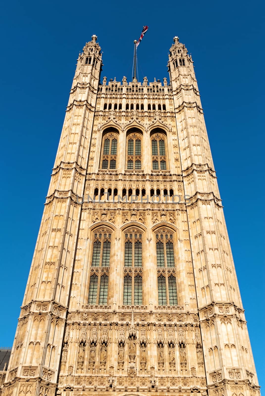 Tower in the building of British Parliament with red bus