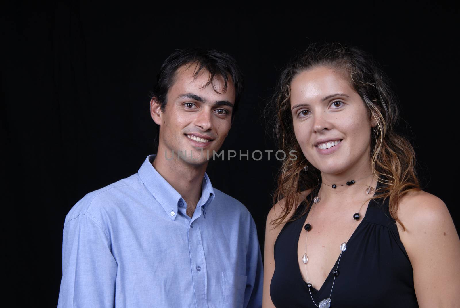 young couple together portrait on black background