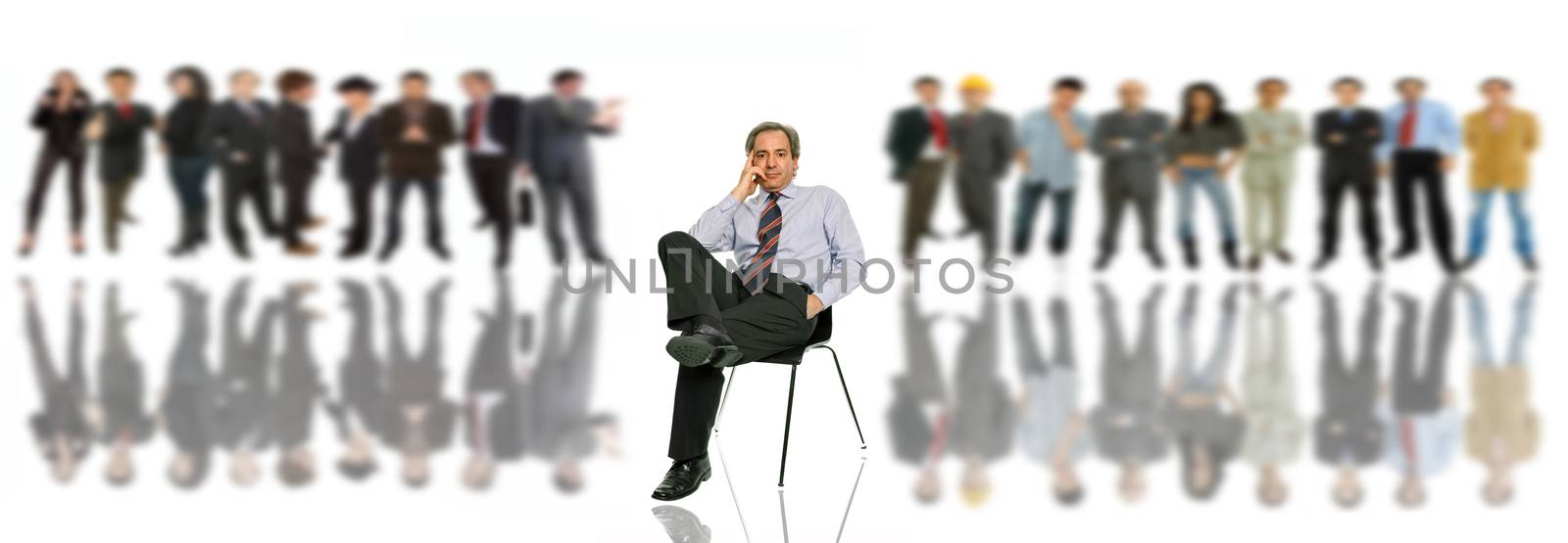 mature businessman in a chair, with some peple in the back