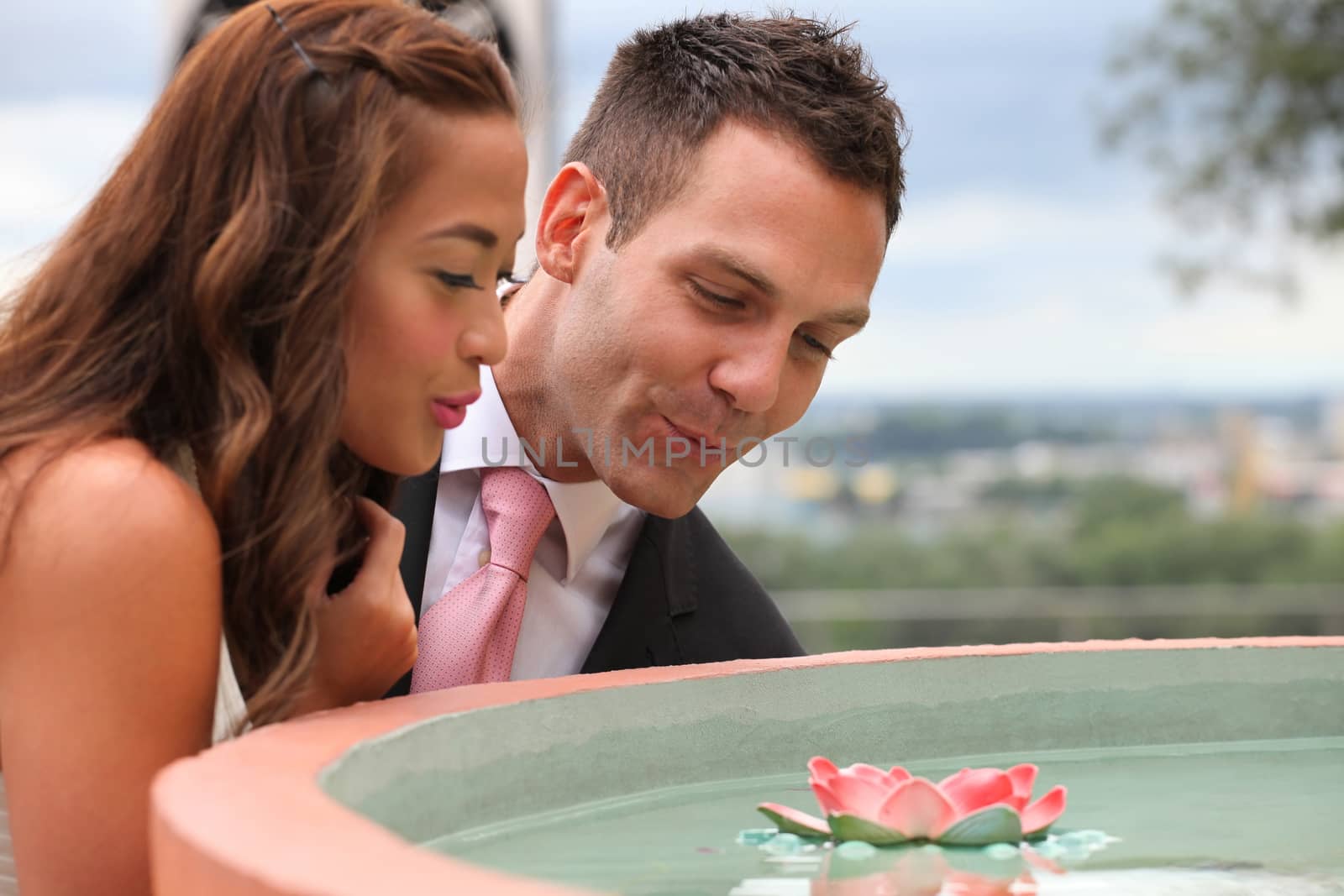 Wedding on the nature, bride and groom looking a water-lily flower