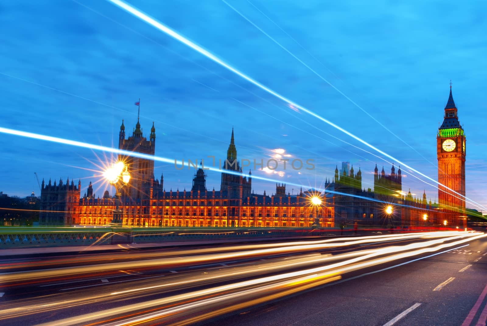 Big Ben, one of the most prominent symbols of both London and England, as shown at night along with the lights of the cars passing by