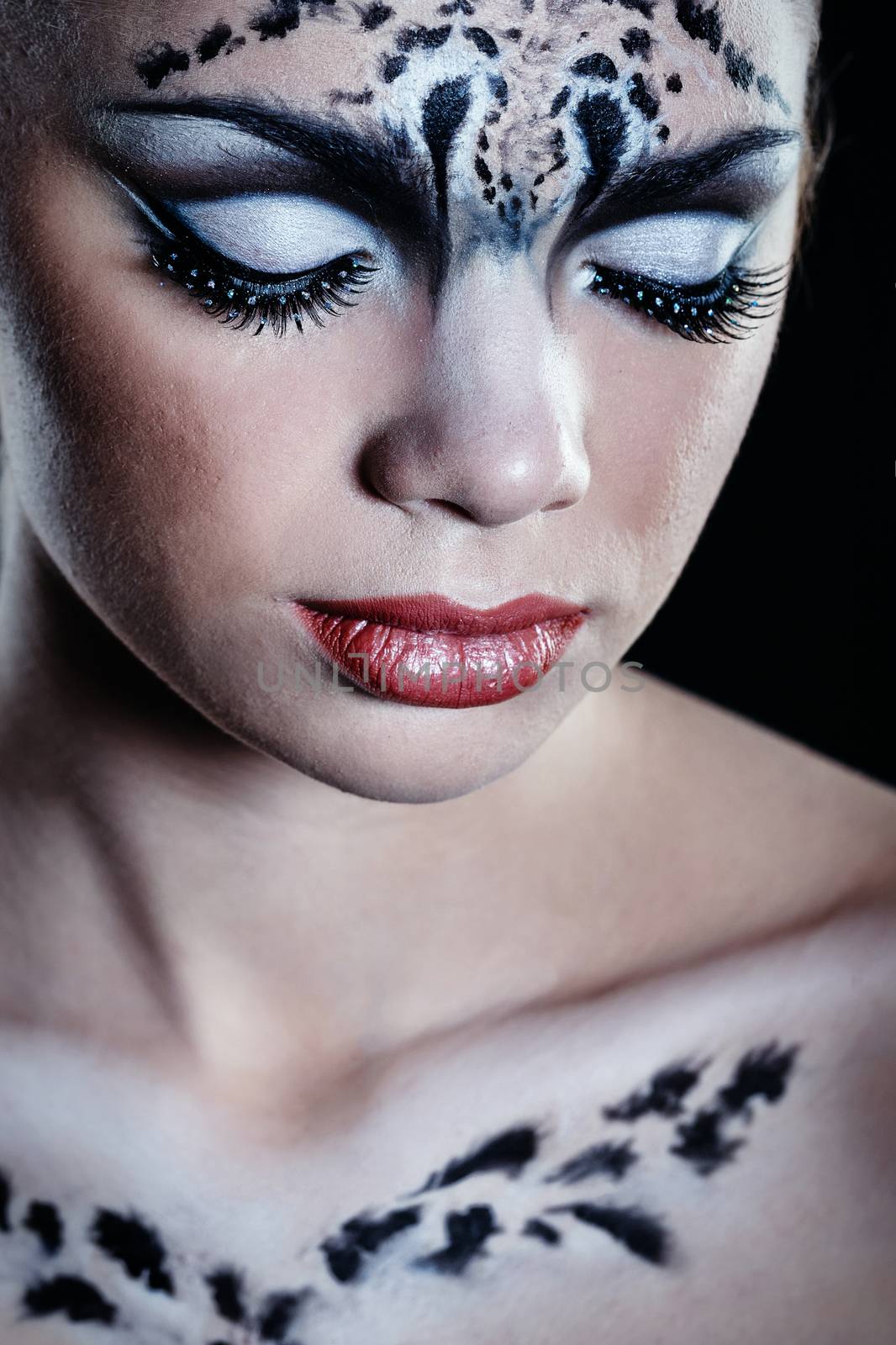 Attractive young girl with make-up snow leopard close-up portrait