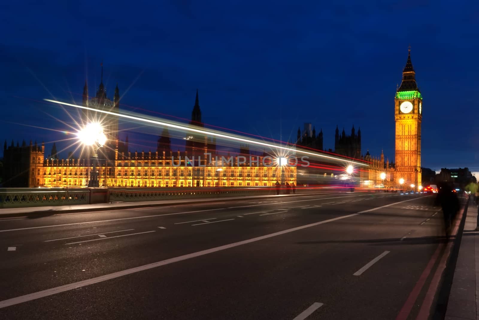 Big Ben, one of the most prominent symbols of both London and England, as shown at night along with the lights of the cars passing by by mitakag