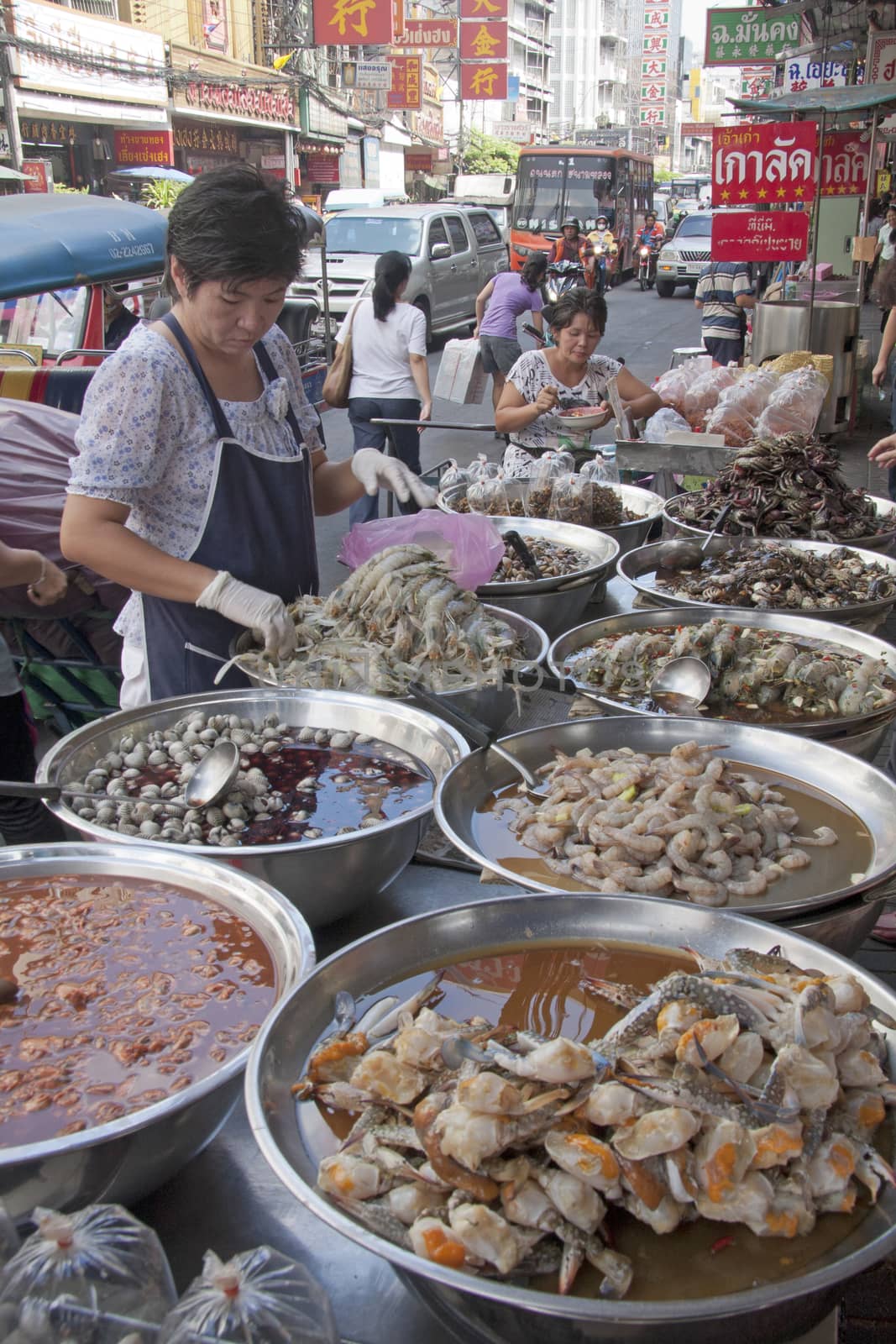 Bangkok, Thailand-December 7th 2011: A woman serves seafood on a stall in Chinatown. Chinatown is one of the oldest areas in Bangkok.