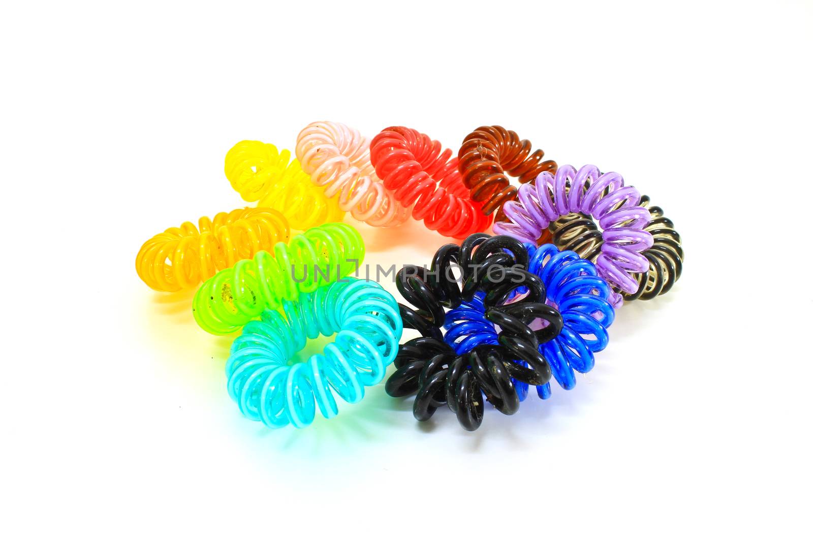 Spiral colorful elastic hair ties used on a white background.