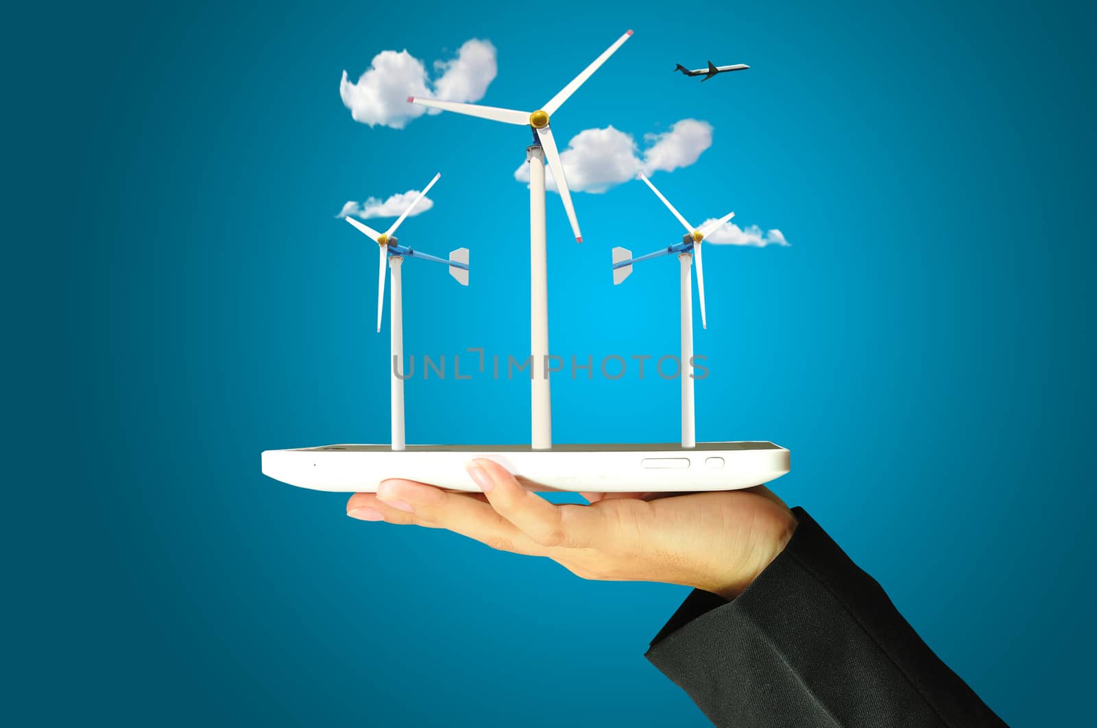 female hand holding a tablet touch computer gadget present wind turbine power generator 
