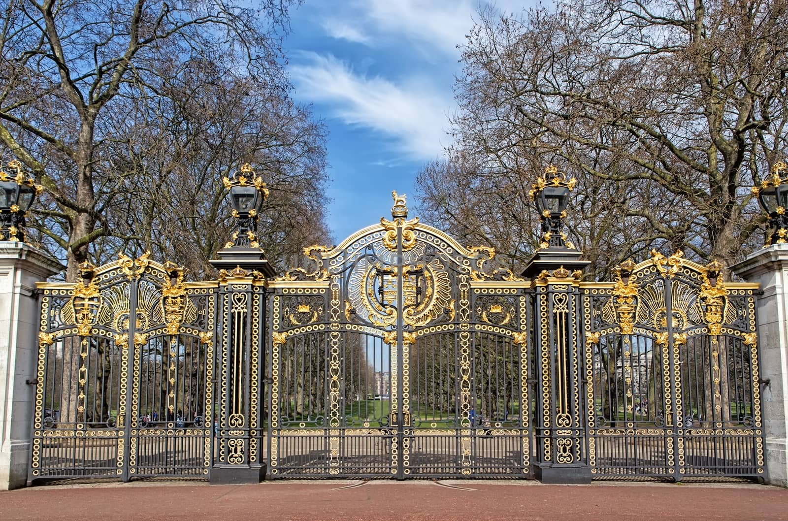 Metal gate of a park decorated with golden ornaments 