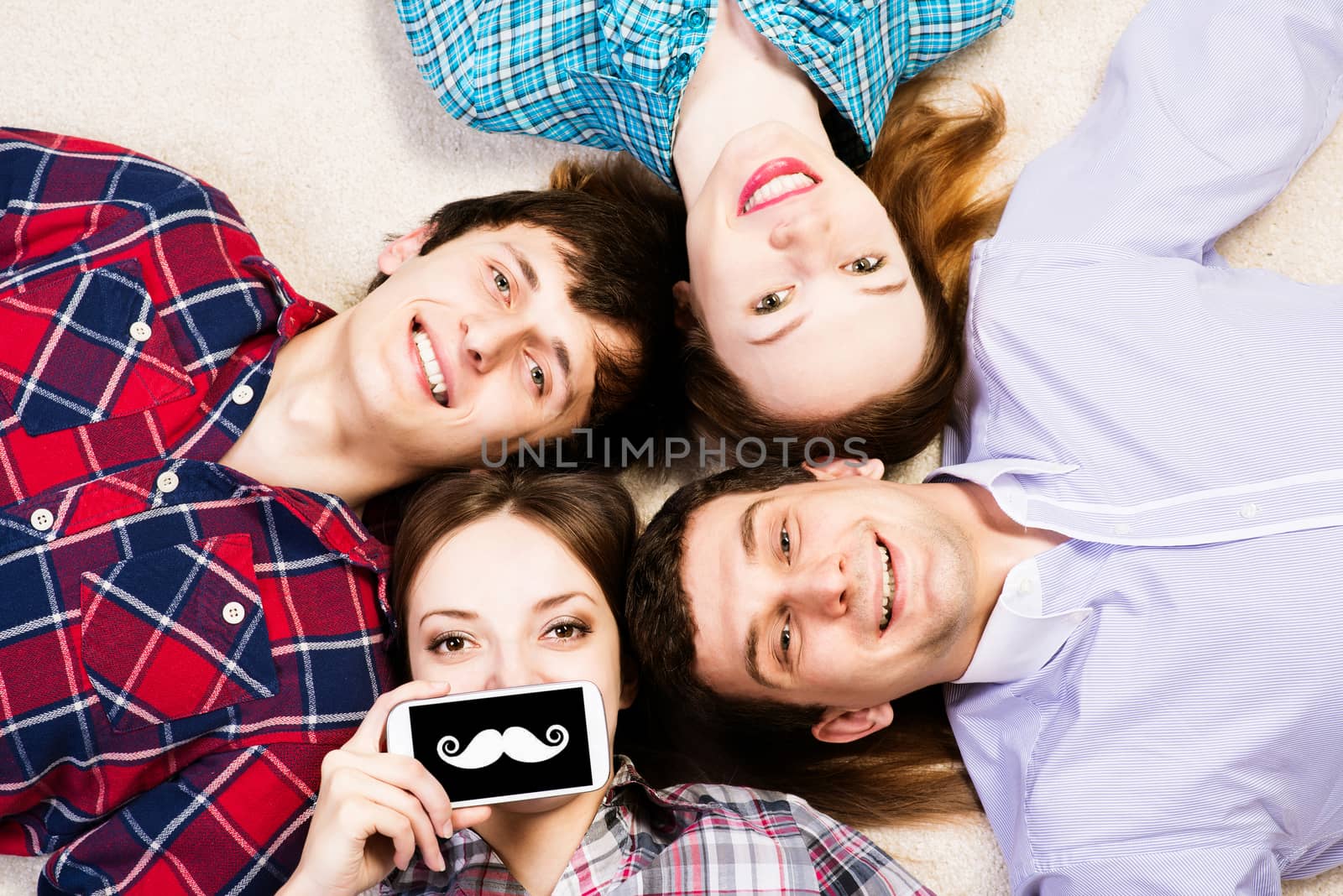 four young men lie together, young attractive woman pressed her lips to the phone