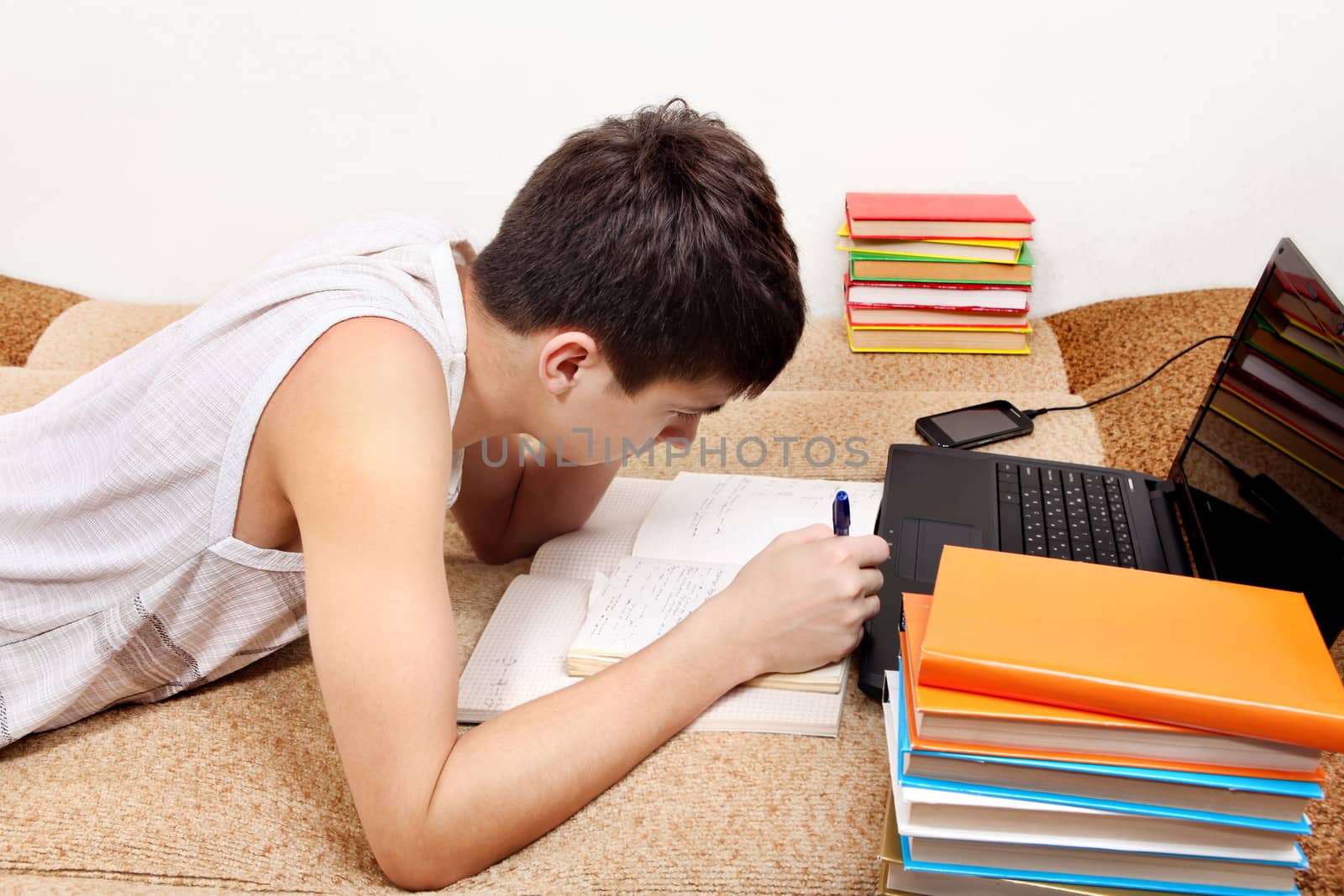 Side view of the Teenager doing Homework at the Home