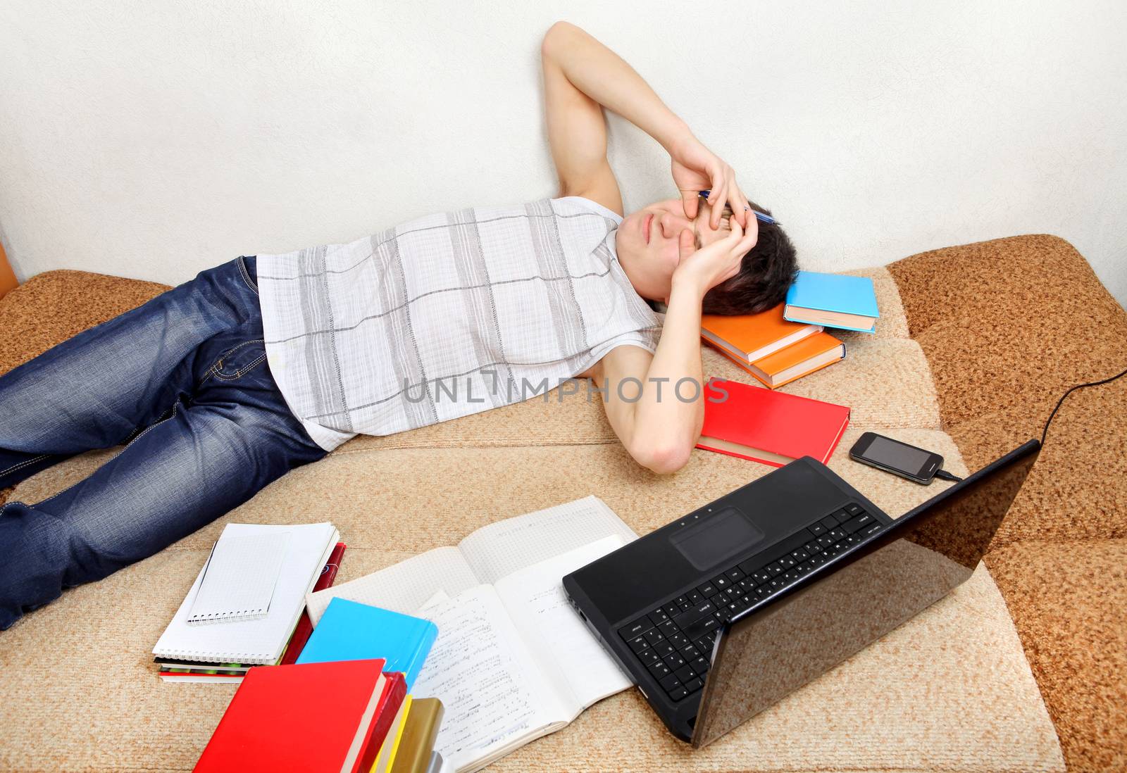 Sleepy Teenager with the Books and Laptop on the Sofa at the Home