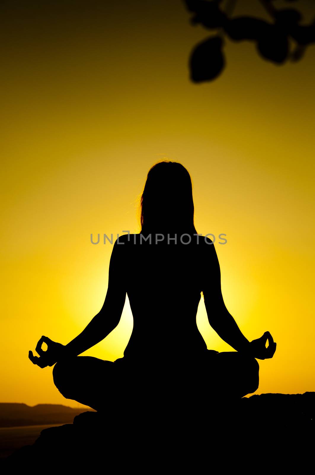 Young model is doing yoga on seaside at sunrise