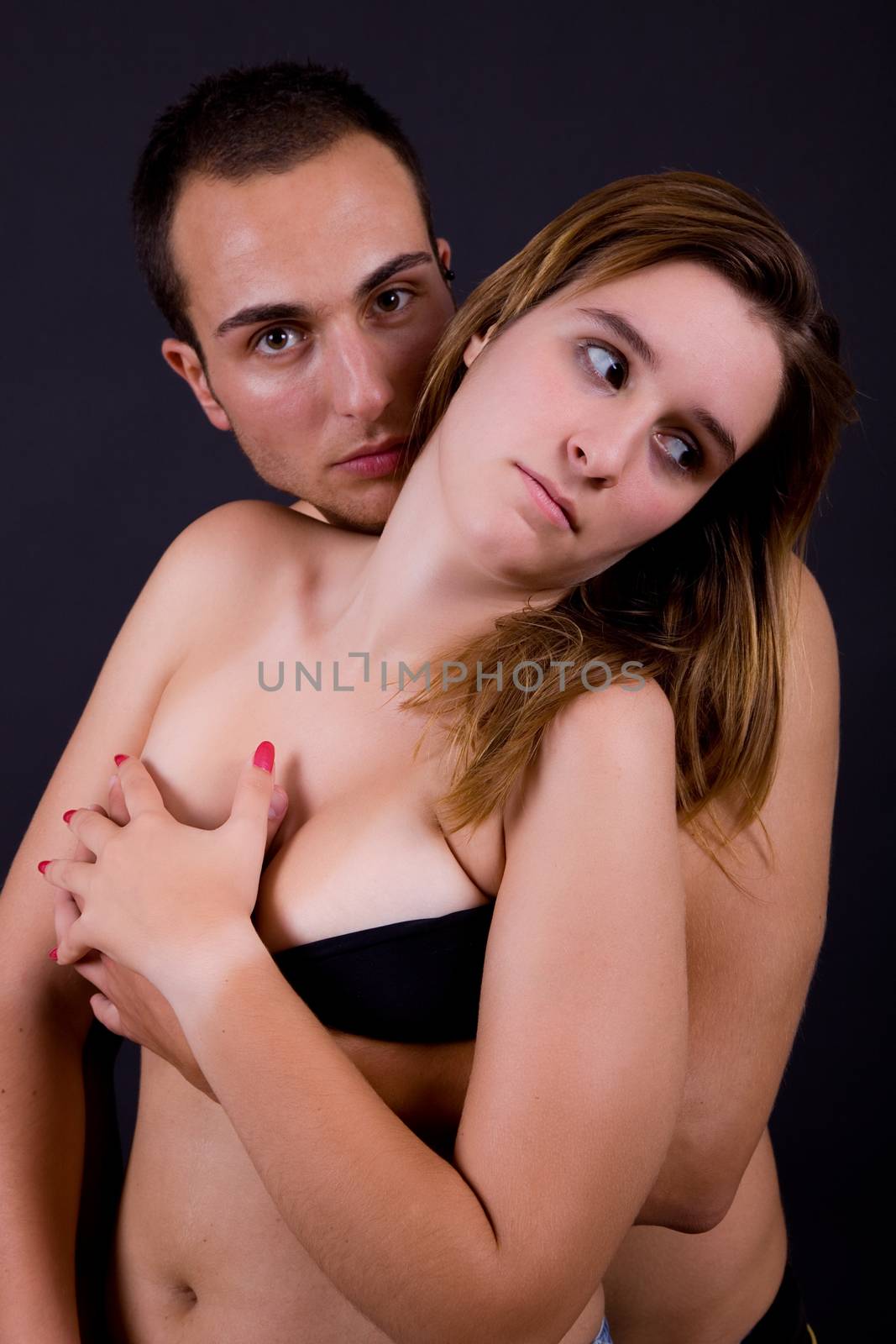 young couple together portrait on black background