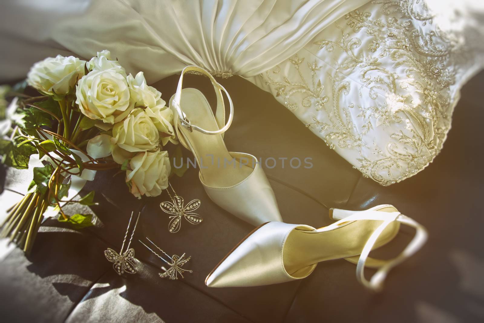 Wedding shoes with bouquet of white roses  on chair