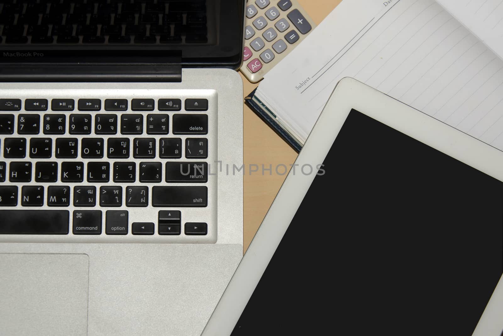 Notebook computer and  book placed on the desks.