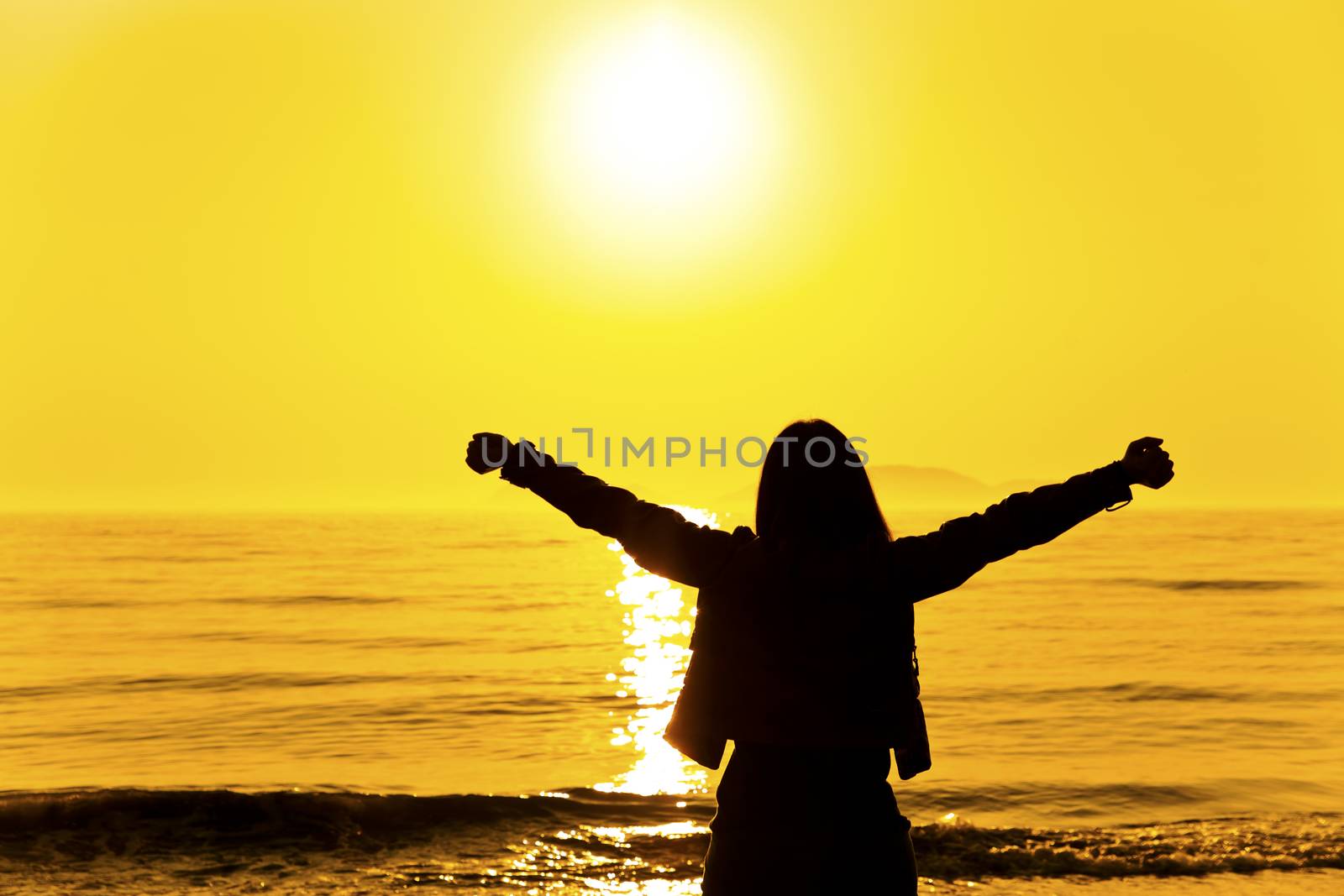 Silhouette of a woman relaxing at sunset