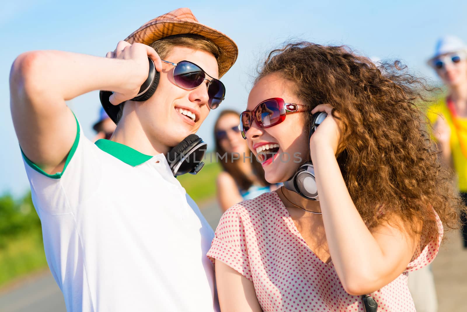 young couple standing on the road, having fun with friends