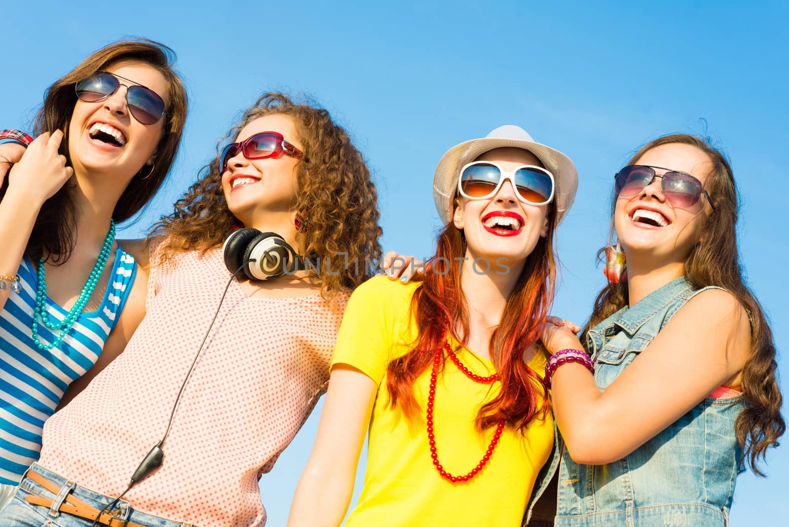 group of young people wearing sunglasses and hats hugging and standing in a row, spending time with friends