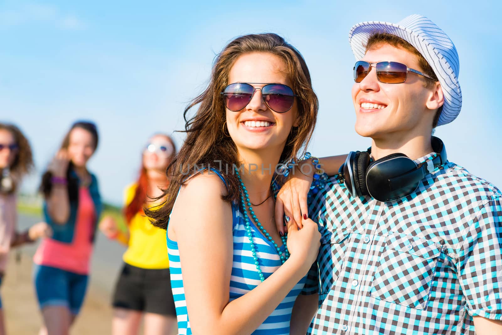 young couple standing on the road, having fun with friends