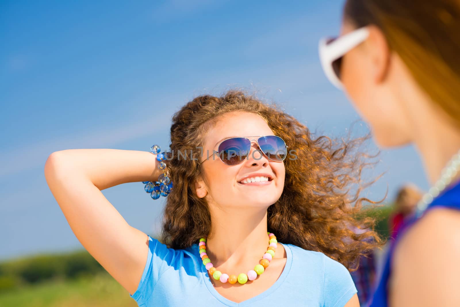 portrait of a stylish young woman on the background of young merry friends, spending time with friends