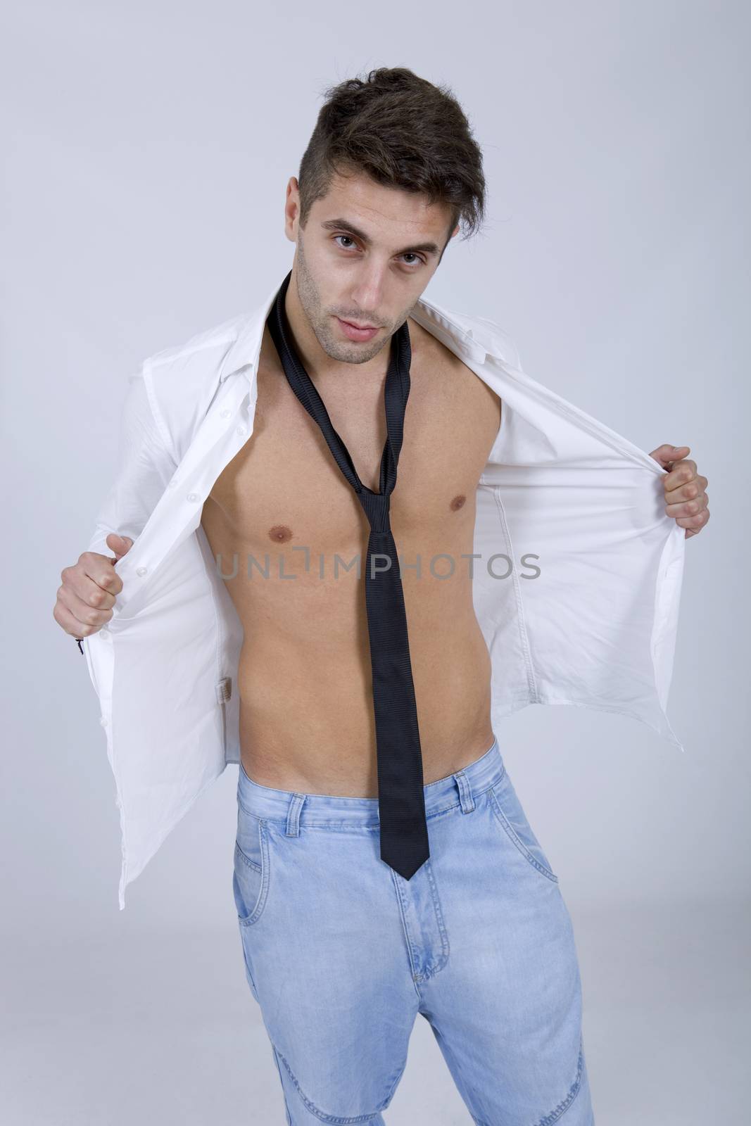 young sensual casual man portrait on a grey background