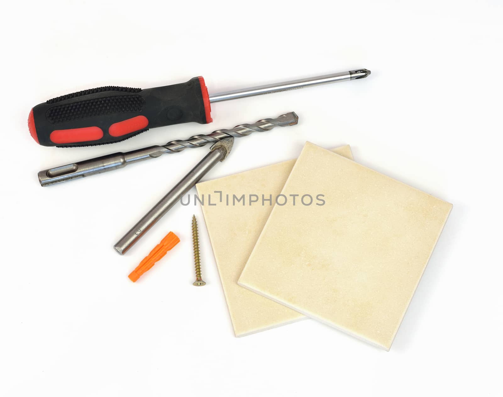 Screwdriver, drill and ceramic tiles. Isolated on white background