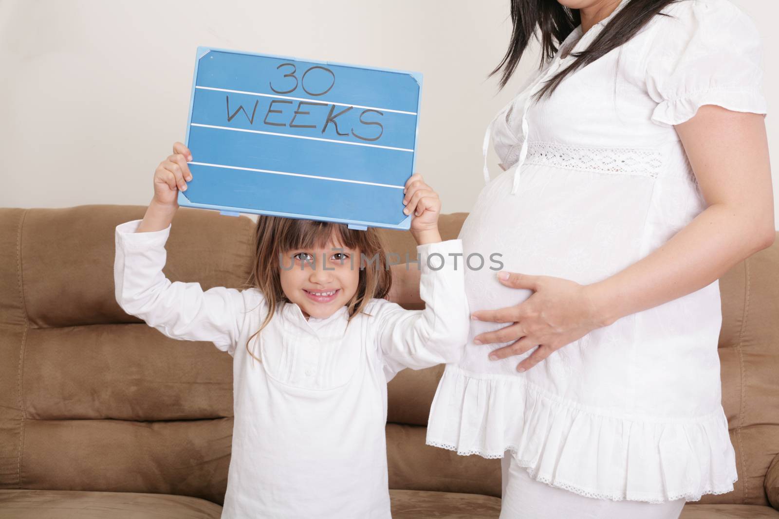 Girl holding a 30 weeks sign to her expectant mother by dacasdo