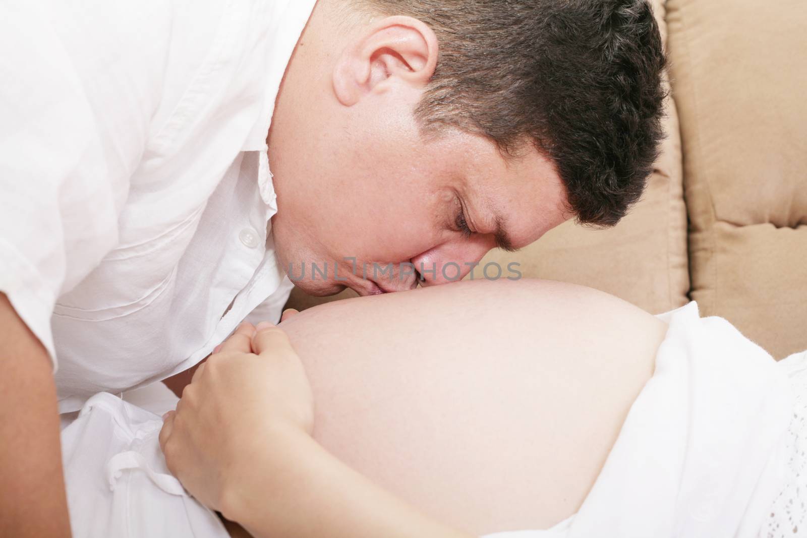 man kiss a stomach of the pregnant woman