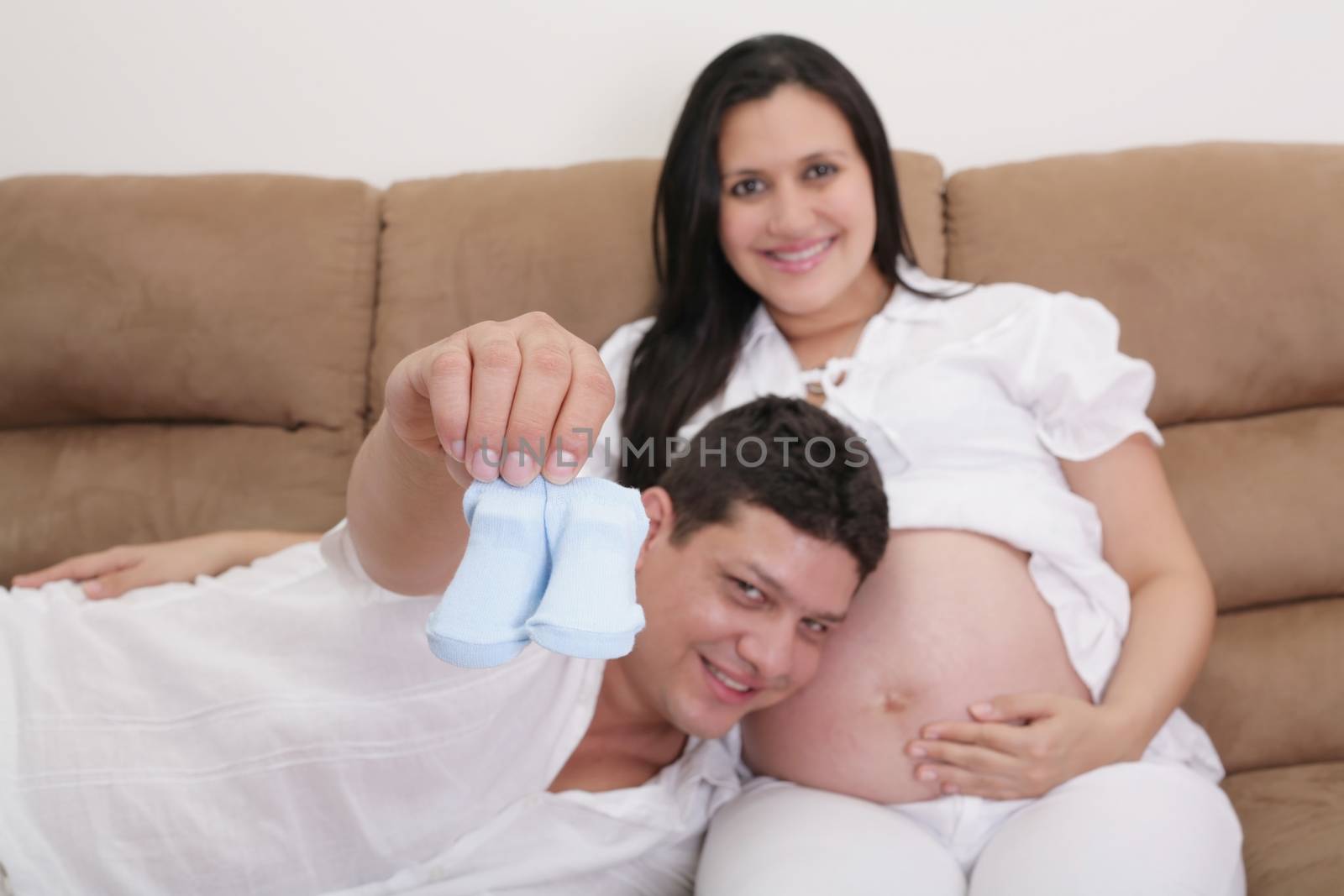 happy couple expecting a baby with socks in hand. Focus in the by dacasdo
