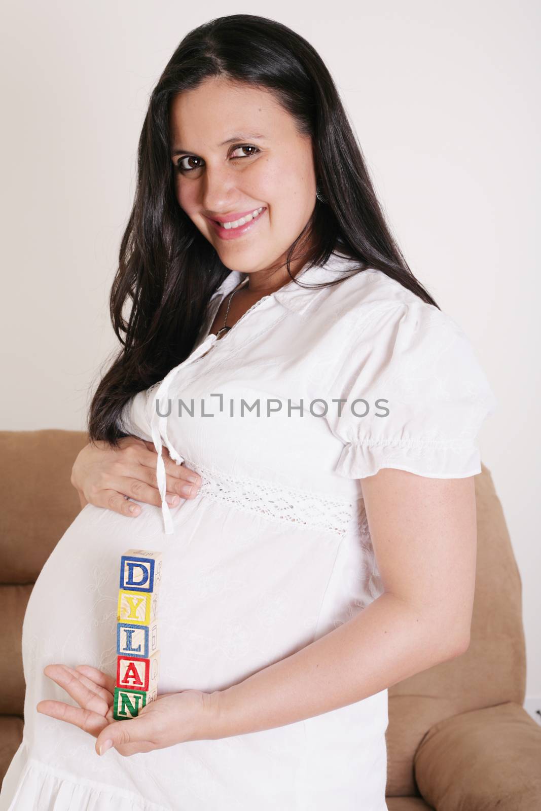 Close up of a pregnant woman with baby letters on her hand