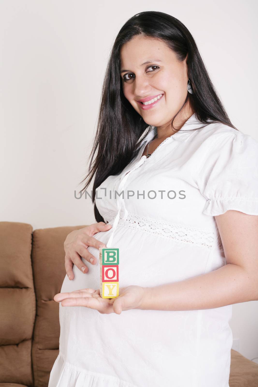 Beautiful hispanic pregnant woman having the word boy with woode by dacasdo